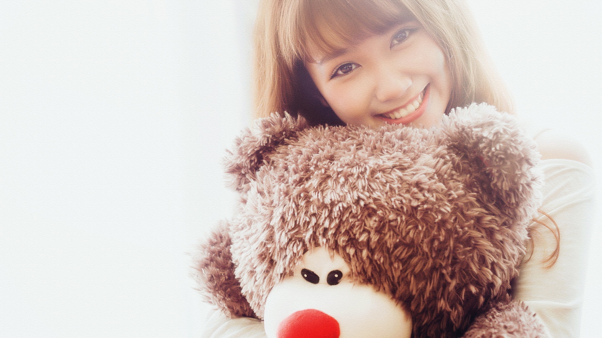 抱着玩具熊的可爱微笑女孩桌面壁纸